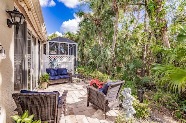 view of patio featuring glass enclosure and an outdoor living space