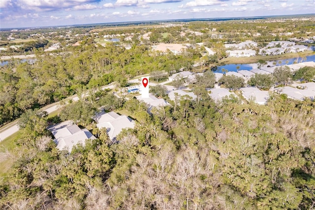 bird's eye view featuring a residential view, a water view, and a wooded view