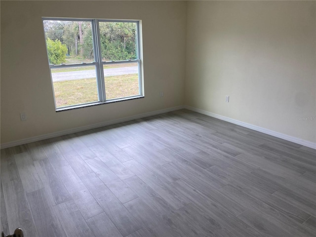 empty room featuring dark wood-type flooring and baseboards