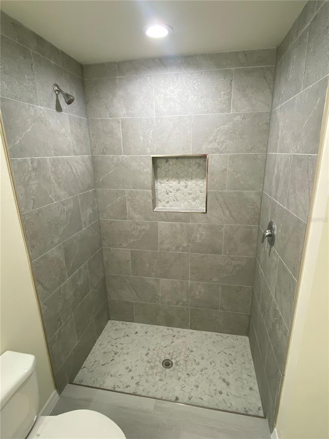 full bath featuring a shower stall and toilet