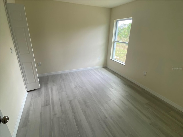 empty room with light wood-style floors and baseboards