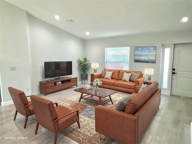 living room featuring light wood-style flooring, baseboards, and recessed lighting