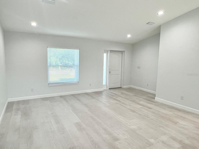 spare room with recessed lighting, light wood-type flooring, and baseboards