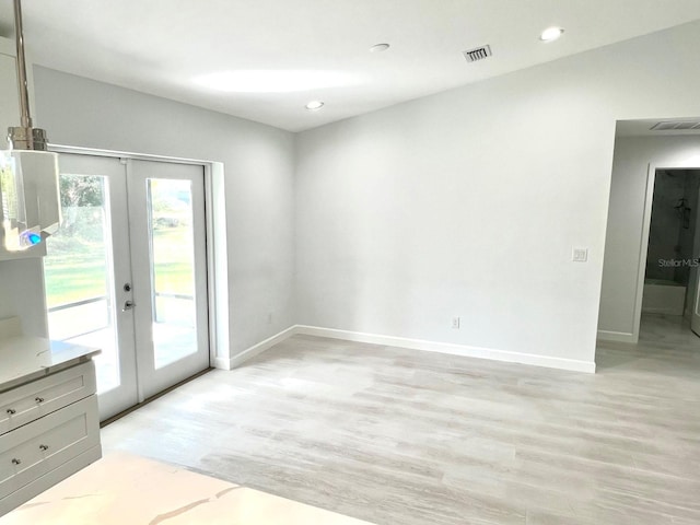 doorway featuring french doors, light wood-style flooring, and baseboards