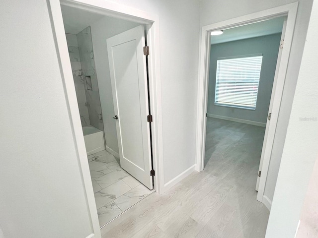 hall featuring marble finish floor and baseboards