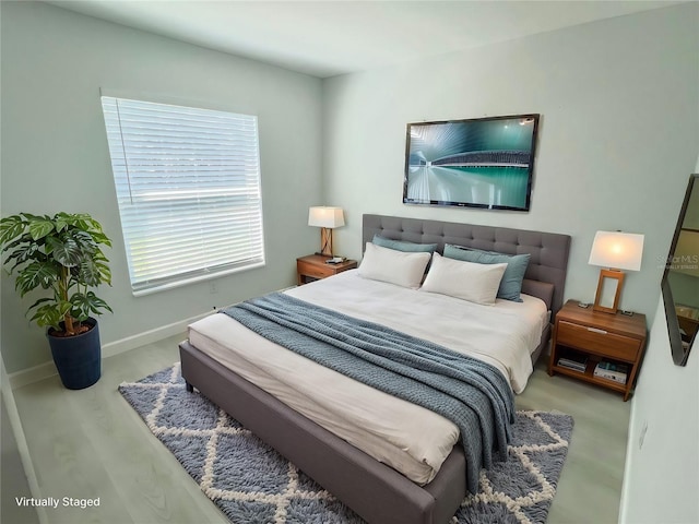 bedroom featuring baseboards and wood finished floors