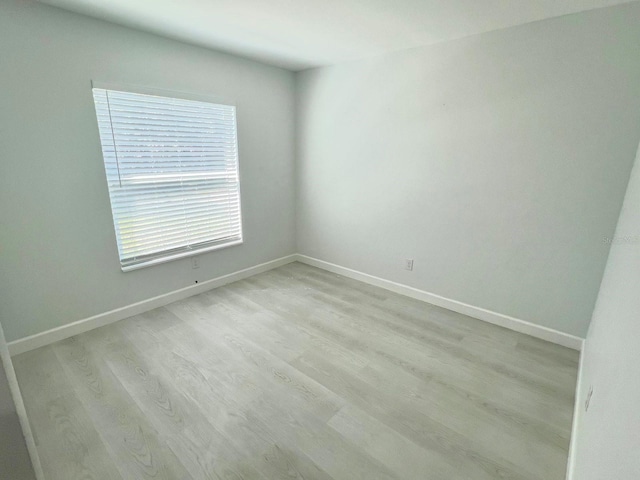 unfurnished room featuring light wood-type flooring and baseboards