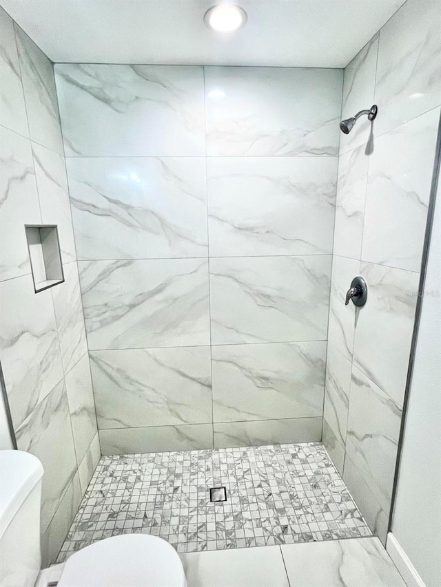 full bath featuring a shower stall and toilet