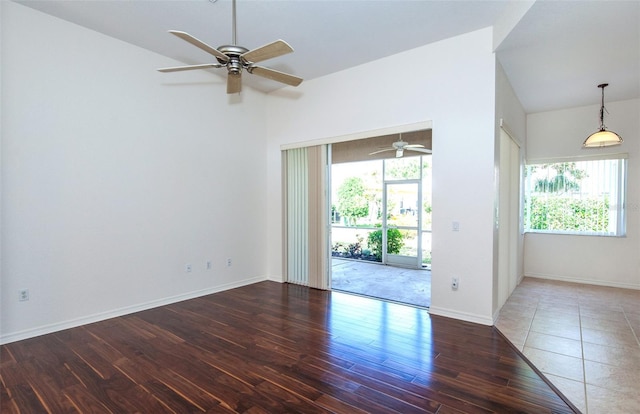 empty room with a healthy amount of sunlight, baseboards, and wood finished floors