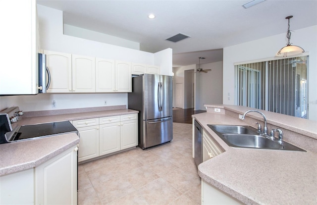 kitchen featuring light countertops, hanging light fixtures, appliances with stainless steel finishes, white cabinetry, and a sink