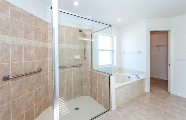 bathroom with tile patterned floors, a garden tub, a walk in closet, a shower stall, and recessed lighting