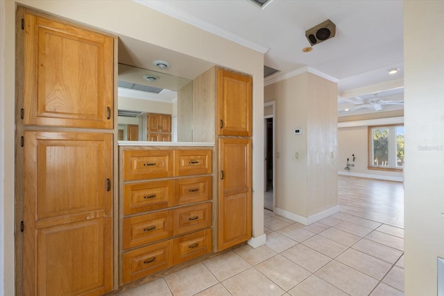 hallway with light tile patterned floors, baseboards, and ornamental molding