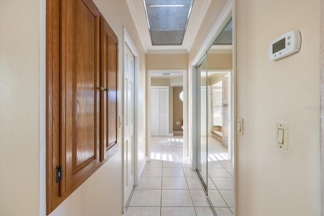 hall with light tile patterned floors and crown molding