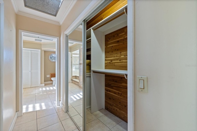 hall with light tile patterned flooring, visible vents, and ornamental molding