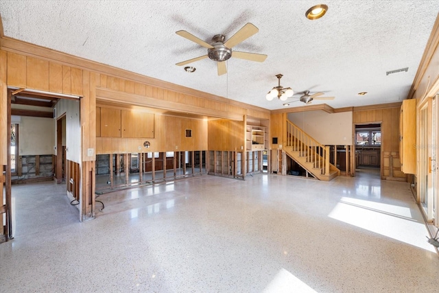 unfurnished room with visible vents, a textured ceiling, speckled floor, ceiling fan, and stairs