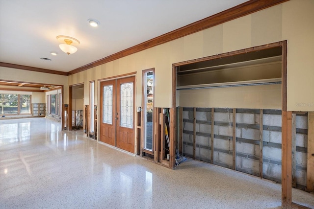 entrance foyer featuring speckled floor and crown molding