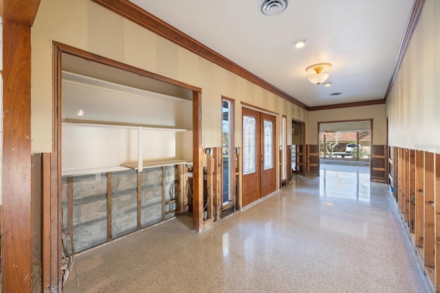 foyer featuring visible vents, speckled floor, and ornamental molding