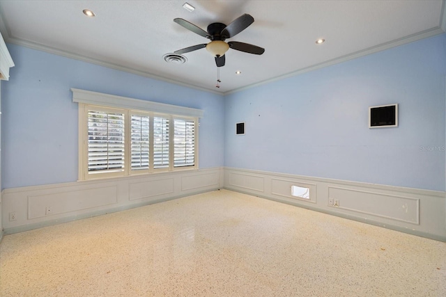 empty room featuring a wainscoted wall, visible vents, recessed lighting, ornamental molding, and ceiling fan