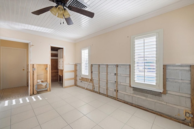 unfurnished room with a ceiling fan, light tile patterned flooring, wainscoting, crown molding, and wood ceiling