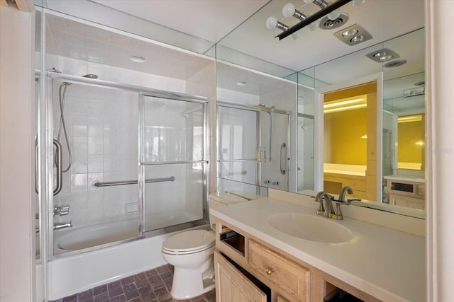 full bath featuring toilet, vanity, and shower / bath combination with glass door