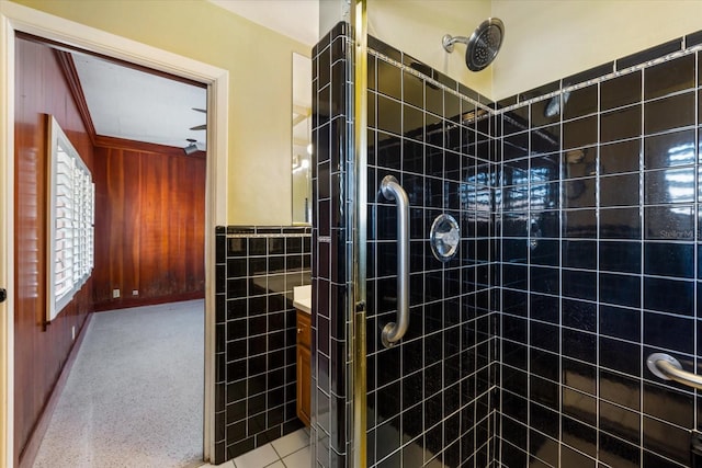 bathroom with vanity, tile walls, a stall shower, and wainscoting