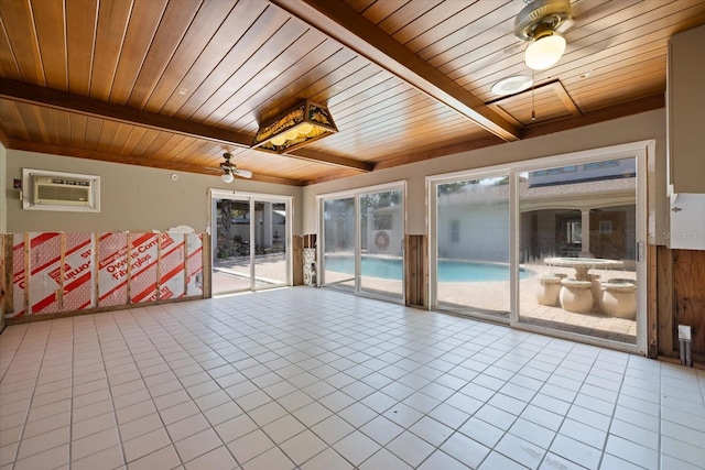 interior space with beamed ceiling, an AC wall unit, ceiling fan, and wooden ceiling