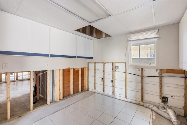 miscellaneous room with tile patterned flooring and a paneled ceiling