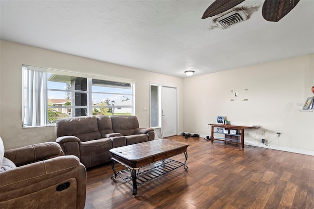 living room featuring baseboards, visible vents, and wood finished floors