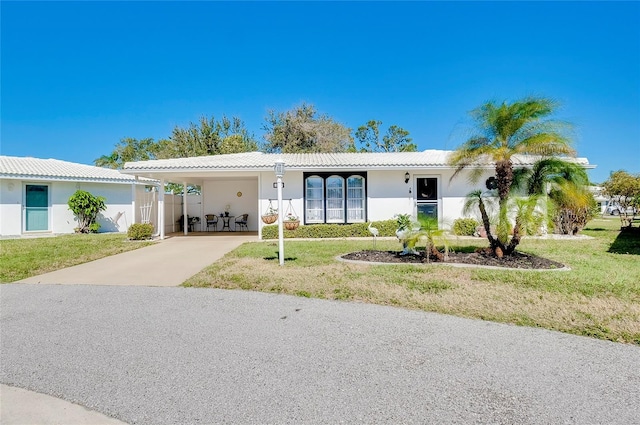 view of front of home with driveway, a tile roof, a front lawn, and an attached carport