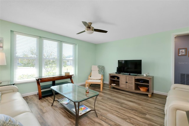 living area featuring visible vents, a ceiling fan, baseboards, and wood finished floors