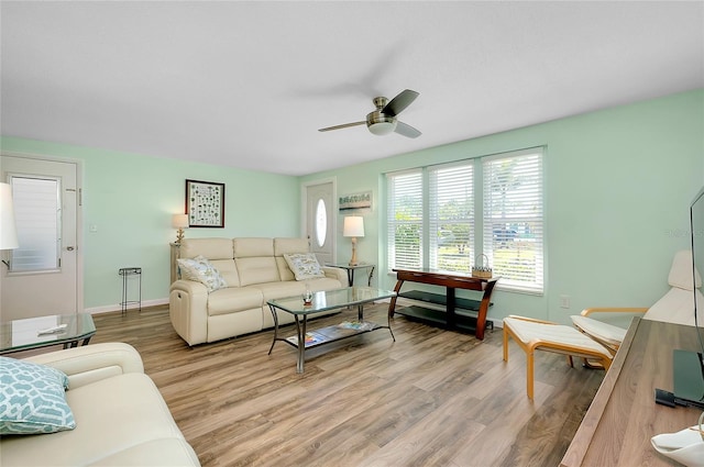 living room with baseboards, a ceiling fan, and light wood finished floors