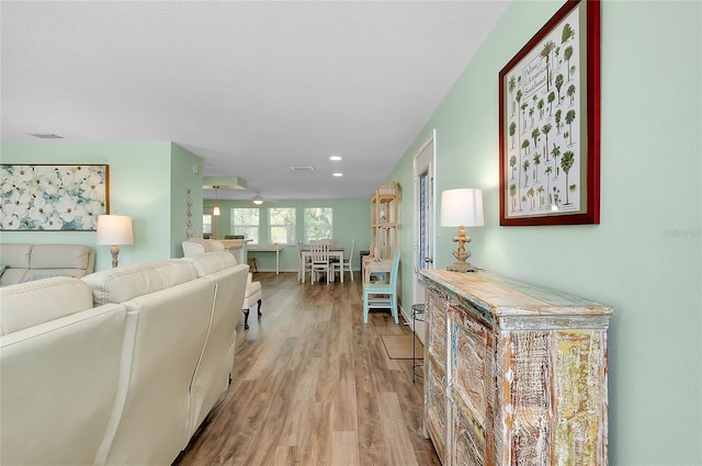 living area with a ceiling fan and light wood-style floors