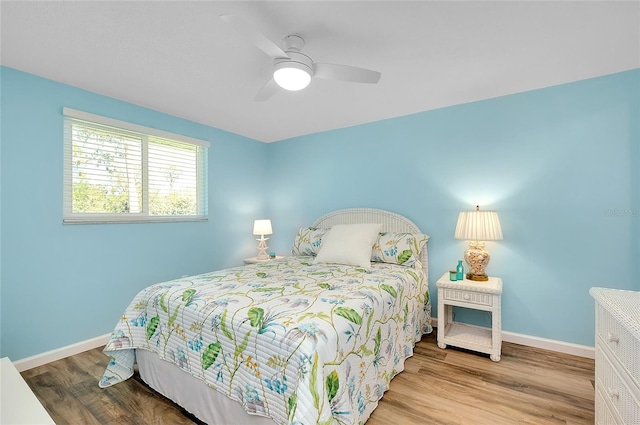 bedroom featuring wood finished floors, baseboards, and ceiling fan