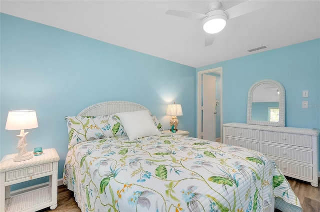 bedroom featuring ceiling fan, visible vents, and wood finished floors