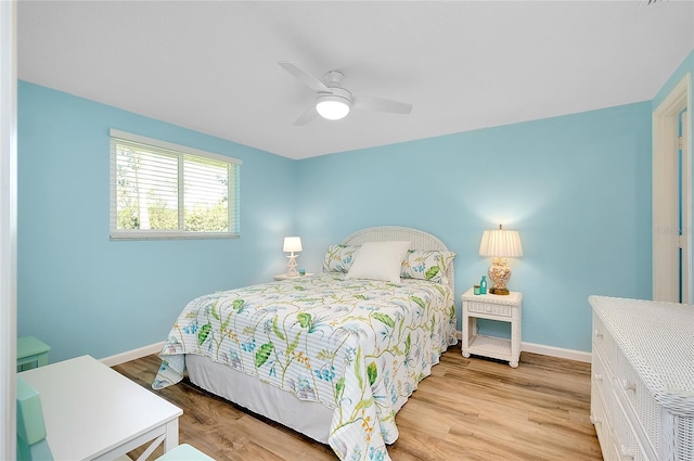 bedroom featuring ceiling fan, baseboards, and light wood-style flooring