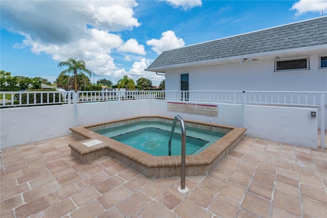 view of pool with a patio area, a community hot tub, and fence