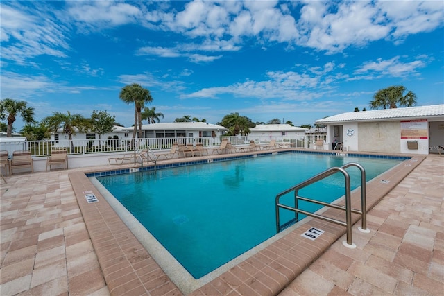 community pool featuring a patio and fence