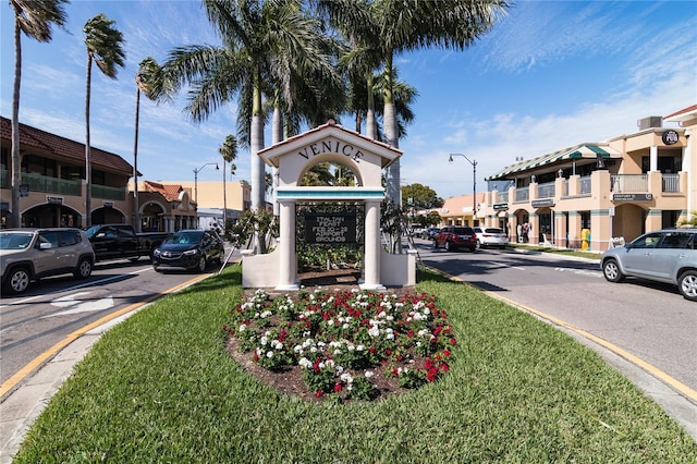 community sign with a residential view and a lawn