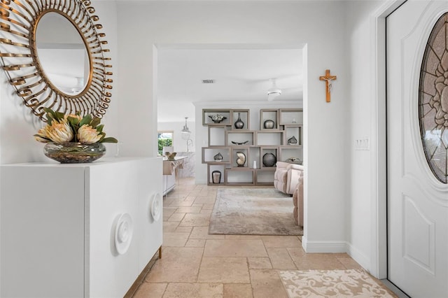 foyer with visible vents, stone tile flooring, and baseboards