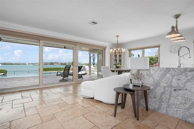 living room featuring plenty of natural light, stone tile floors, visible vents, and crown molding