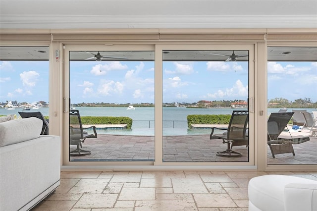 entryway featuring a water view, crown molding, and stone tile floors