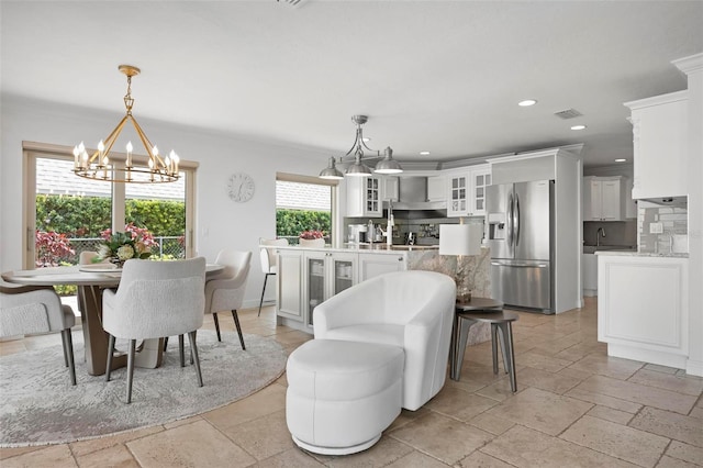 dining space featuring stone tile floors, visible vents, an inviting chandelier, crown molding, and recessed lighting