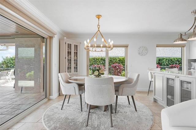 dining room with stone tile flooring, a notable chandelier, ornamental molding, and a wealth of natural light