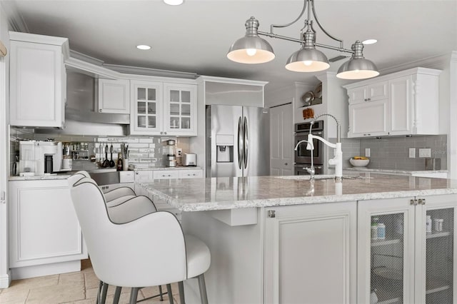 kitchen with appliances with stainless steel finishes, white cabinets, a sink, and backsplash