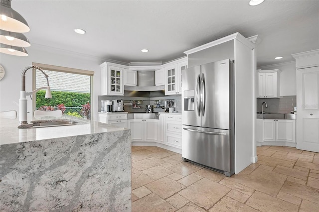 kitchen with ornamental molding, stone tile flooring, a sink, and stainless steel refrigerator with ice dispenser