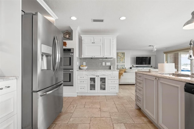 kitchen featuring appliances with stainless steel finishes, recessed lighting, stone tile flooring, and decorative backsplash