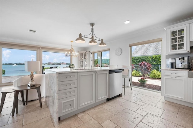 kitchen with crown molding, a sink, dishwasher, and stone tile floors