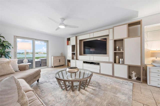 living room featuring stone tile floors and ceiling fan