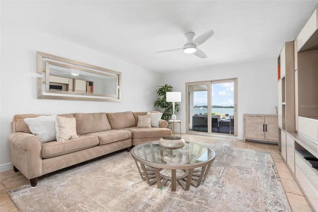 living area featuring a ceiling fan and baseboards