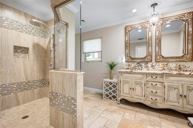 full bath featuring double vanity, stone tile flooring, ornamental molding, baseboards, and walk in shower